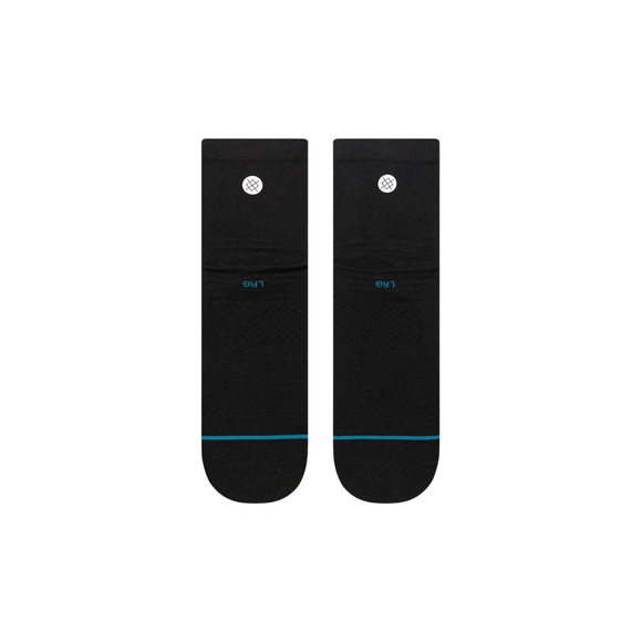 Et par sorte unisex-strømper fra Stance Solid UL Quarter ligger fladt side om side på en hvid baggrund med en tynd blå linje ved tæerne og et hvidt cirkelformet logo øverst.