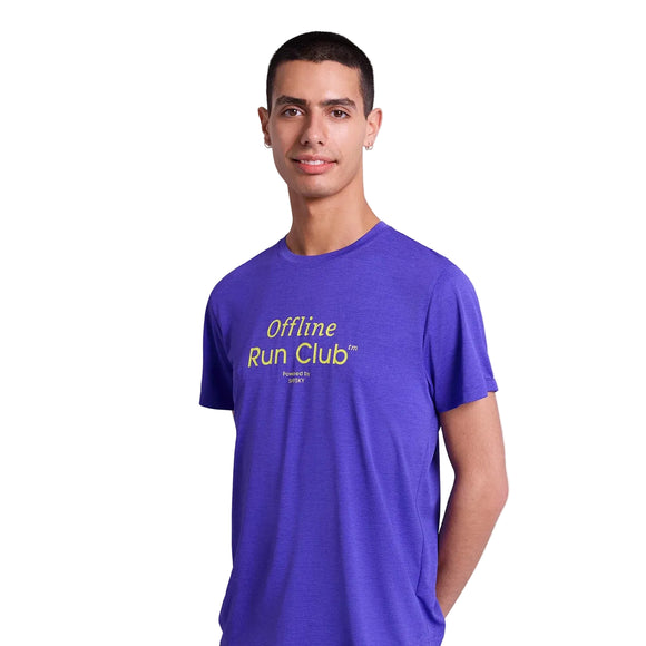 En mand med kort mørkt hår står på en almindelig hvid baggrund iført Saysky Statement Combat Pro T-shirt, Herre, Purple, med gul "Offline Run Club"-tekst. Denne åndbare sportstøj er designet til komfort.