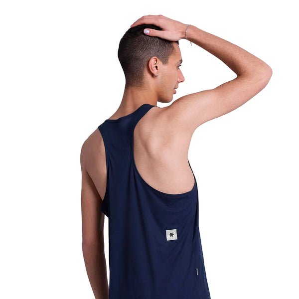 En mand med kort hår bærer en mørkeblå Saysky Statement Flow Singlet, Herre, Blue, med ansigtet vendt væk og en hånd på hovedet. Singletten har et lille rektangulært felt nær lænden, ideelt til herre løbetøj-fans.