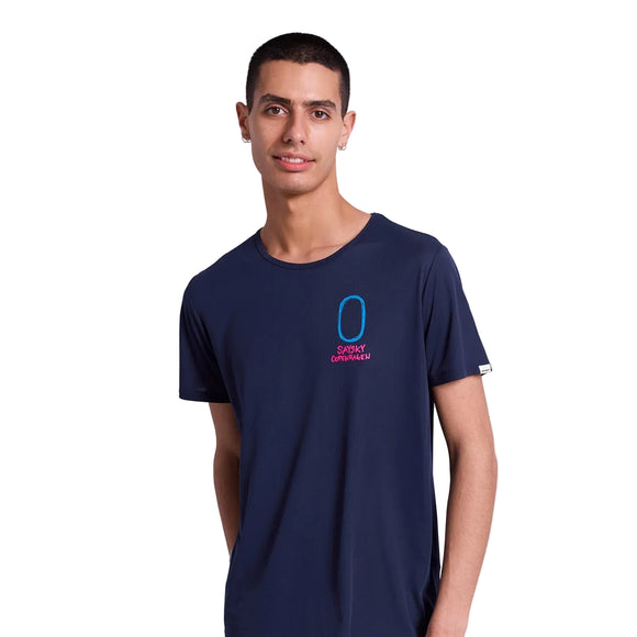 En ung mand med kort mørkt hår bærer en Saysky Statement Flow T-Shirt, Herre, Blue med en lille blå og rød grafik og tekst på venstre bryst, lavet af svedtransporterende materiale, stående mod en hvid baggrund.