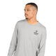 En mand med kort hår og et velplejet skæg har en Saysky Statement Pace Long Sleeve, Herre, Grå, på, med et SAYSKY Copenhagen-logo på venstre bryst. Han kigger til venstre foran en ensfarvet lys baggrund. Det hurtigtørrende materiale sikrer optimal komfort under hver eneste løbetur.