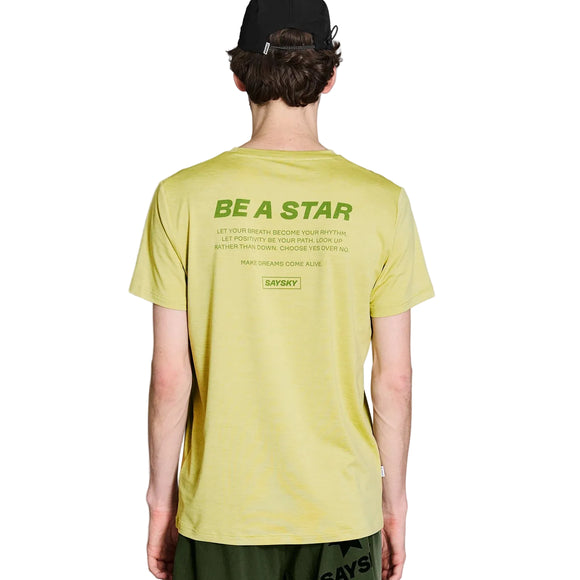 En person iført Saysky Statement Pace T-shirt, Herre, grøn melange med teksten »BE A STAR« på ryggen, samt en sort kasket og grønne shorts, ses set bagfra – den perfekte inspiration til herretræning på en hvid baggrund.