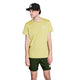 En mand iført en grøn meleret Saysky Statement Pace-T-shirt, mørkegrønne shorts og en sort kasket står foran en hvid baggrund. Alle disse beklædningsgenstande er forsynet med et lille, firkantet, hvidt logo – perfekt til træning eller fritidstøj.