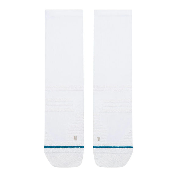 To hvide Stance Fusion Grip Crew-løbesokker ligger fladt side om side, og hver har en tynd blågrøn stribe nær tåområdet. Disse unisex-sokker har et minimalistisk design med diskrete strukturmønstre og skridsikre grippaneler, der giver øget stabilitet. De tydeligt markerede bogstaver L og R på tæerne angiver venstre og højre, hvilket gør disse Stance-sokker både praktiske og stilfulde.