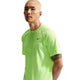 En person med kort blondt hår er iført en neongrøn Nike Stride SS Running Top, Herre, Volt Ice/Reflective Silv, og kigger ind i kameraet med et neutralt udtryk. Baggrunden er helt hvid.