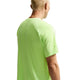 En person med kort blondt hår ses bagfra iført Nike Stride SS Running Top, Herre, Volt Ice/Reflective Silv. Den ensfarvede hvide baggrund fremhæver denne stilfulde løbe t-shirt herre.