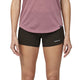 En person er iført en lilla kortærmet skjorte og Patagonia Strider Pro Shorts 3.5", Dame, Black, vist fra midt på torsoen til midt på låret mod en ensfarvet baggrund, der fremhæver disse hurtigtørrende træningsshorts.