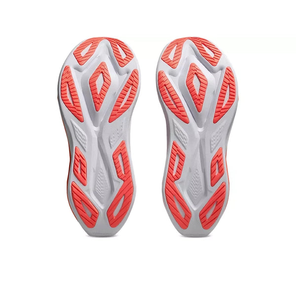 Et par ASICS Superblast 3 Unisex-løbesko i farvekombinationen hvid/orange glow set set fra neden, med hvide såler med orange geometriske mønstre i gummi, der sikrer godt greb, samt riller, der er designet til at supplere den responsive FF LEAP-skumstøddæmpning, som er unik for denne model.