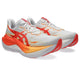 Et par ASICS Superblast 3 unisex-løbesko i farven White/Orange Glow, med hvid overdel med livlige orange og røde detaljer, markante røde ASICS-logoer og tykke hvide og orange mellemsåler, der er udviklet med responsivt FF LEAP-skum. Skoene har røde ydersåler og snørebånd og er afbildet let vinklet mod højre.