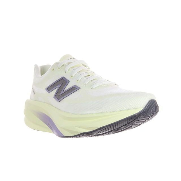 En lysegul og hvid New Balance Supercomp Rebel V1 Dame i farvekombinationen »Pistachio Butter«, med en tyk sål, sort mønster og et mørkt N-logo på siden, vises på en hvid baggrund. Skoen er designet som en responsiv træningssko og er placeret på en måde, der fremhæver både side- og frontprofilen.