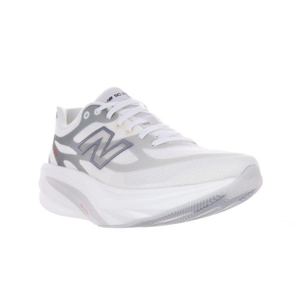 En hvid New Balance Supercomp Rebel V1-løbesko til kvinder i farven Sea Salt med et gråt N-logo på siden, hvide snørebånd, en tyk hvid sål samt diskrete grå og røde detaljer, vist skråt set forfra fra venstre mod en hvid baggrund. Denne lette og responsive FuelCell-sko er designet til at levere både komfort og ydeevne.
