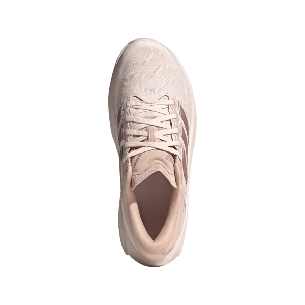 Et billede set ovenfra af Adidas Supernova Prima 3-løbeskoen til kvinder i farvekombinationen Wontau/Vagrme/Dualil fremhæver den lysbeige overdel med diskrete sømme, de klassiske tre striber på siden og snørelukningen, alt sammen på en ensfarvet hvid baggrund. Denne sneaker er udstyret med en avanceret Dreamstrike Pro-mellemsål, der sikrer øget komfort og støtte.