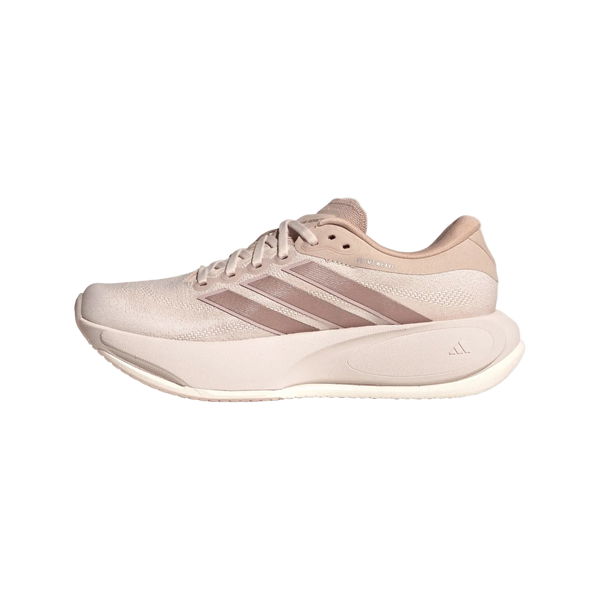 Her ses et billede af en Supernova Prima 3-løbesko til kvinder fra Adidas i farvekombinationen Wontau/Vagrme/Dualil set fra siden. Billedet viser de tre striber, snørebåndene, en stødabsorberende sål, der sikrer komfortabel løb, samt en overdel i netlignende materiale på en ensfarvet hvid baggrund.