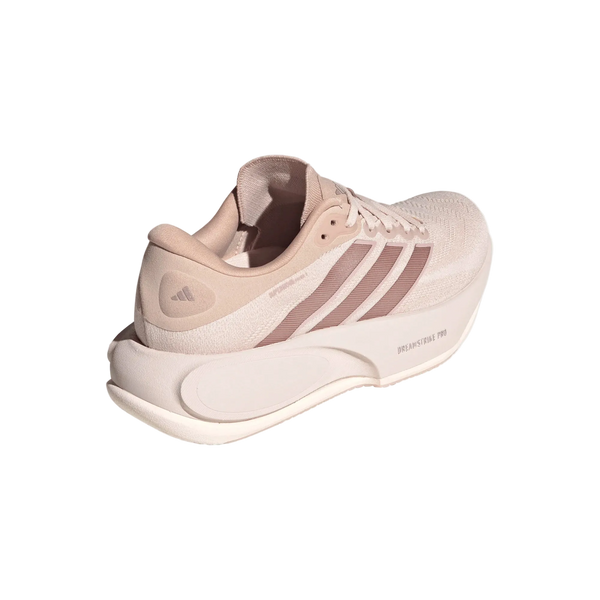 Et par beige (Wontau) og lyserøde (Vagrme/Dualil) Adidas Supernova Prima 3 løbesko til kvinder med de karakteristiske tre striber på siden, en overdel i struktureret stof og en tyk, formet hvid sål. Ideel til komfortløb, med teksten »Dreamstrike Pro« trykt på mellemsålen.