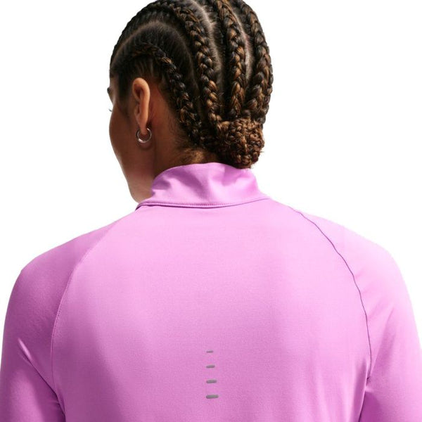 Set bagfra bærer en person med sirligt flettet hår i en lav knold en langærmet Nike Swift UV Half Zip Running Top til kvinder i lys magenta med reflekterende sølvdetaljer.