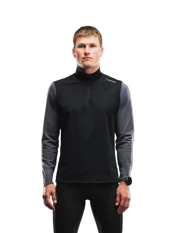 En mand iført en sort og mørkegrå Fusion Tempo! Shield Zip, Herre, Dark Grey langærmet hybrid-løbetrøje med lynlås foran.
