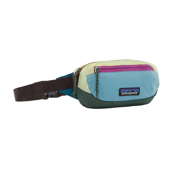 En praktisk Patagonia Terravia Mini Hip Pack, unisex, i farvekombinationen »Patchwork: Snowmelt Blue«, med en sort, justerbar rem, en lynlåslomme foran og et markant mærkelogo på forsiden. Denne flerfarvede taske er designet som et løbebælte og har sektioner i pastellgrøn, lyseblå, lyserød og mørkegrøn, hvilket giver et livligt look.