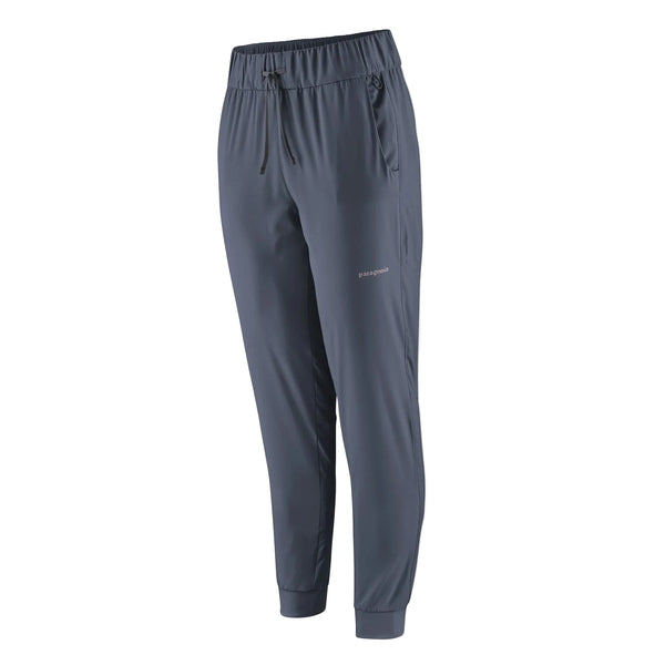Patagonia Terrebonne Joggers til kvinder i Smolder Blue har elastisk linning, justerbar løbegang, sidelommer med lynlås og manchetter ved anklerne, vist på en almindelig hvid baggrund.