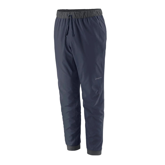 Et par Patagonia Terrebonne Joggers, herre, New Navy, med elastisk linning med snøre og elastiske bukseben. Disse lette bukser er fremstillet af genanvendt polyester og har et lille logo på venstre lår.