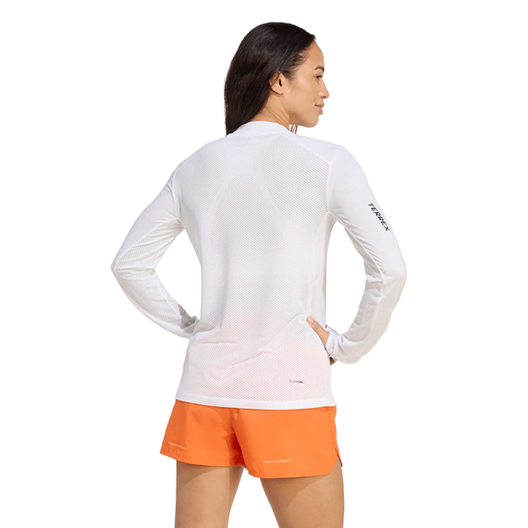 En person set bagfra, iført en hvid Adidas Terrex Xperior Climacool+ langærmet trøje med logo på venstre ærme og lysorange sportsshorts.