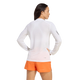 En person set bagfra, iført en hvid Adidas Terrex Xperior Climacool+ langærmet trøje med logo på venstre ærme og lysorange sportsshorts.