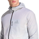 En person iført Adidas Terrex Xperior Light Windweave-jakken, herre, sort/hvid, med sort lynlås og et Adidas-logo på venstre brystlomme. Billedet fokuserer på overkroppen og en del af ansigtet på en hvid baggrund og fremviser denne stilfulde vindjakke, der er designet til trail-løbsentusiaster.