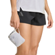 En person iført en Adidas Terrex Xperior Light Windweave-jakke til kvinder i sort og hvidt holder en lille, lys farvet snørepose i sin venstre hånd. Kun den nedre del af overkroppen og de øverste lår er synlige på en ensfarvet baggrund.