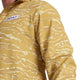En person iført Saysky Tiger Pace Jacket, Herre, Yellow Camo - en gul og beige camouflage løbejakke med vindbeskyttelse. Saysky-logoet vises på et hvidt brystmærke; kun overkroppen og en del af den ene arm er synlige.