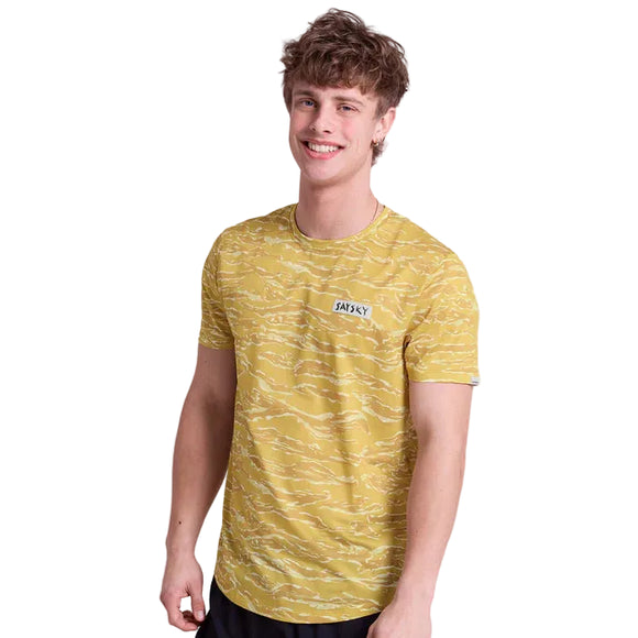 En ung mand viser Saysky Tiger Combat T-Shirt til mænd i gul camouflage med et lille logo på brystet mod en hvid baggrund, mens han smiler til kameraet.
