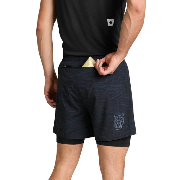 Bagfra-billede af en person iført sorte Tiger Pace 2-i-1-shorts i camouflagemønster, 5′’, Herre, med en baglomme med lynlås og et tigerlogo på benet.