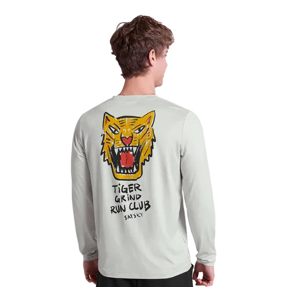 En person ses bagfra iført en Saysky Tiger Pace Long Sleeve, Herre, Grey, med et stort illustreret tigerhoved og "TIGER GRIND RUN CLUB SAYSY" trykt på ryggen.