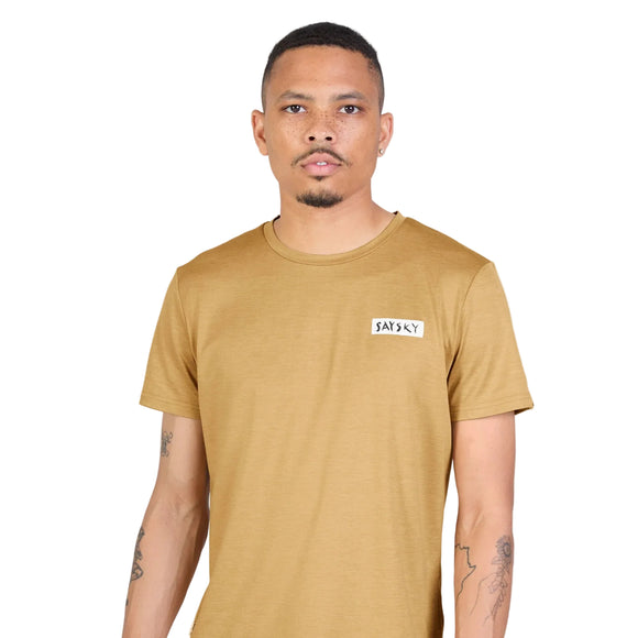 En mand iført en beige Saysky Tiger Pace-T-shirt med et lille rektangulært logo-mærke på brystet.