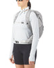 Der ses en person med solbriller, en hvid langærmet trøje, sorte shorts og et hvidt bandana, der har Salomon Trailblazer 20 (Unisex, Cloudburst/Paloma/Silver) på, stående foran en ensfarvet hvid baggrund.