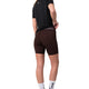 En person står med ryggen til kameraet og er iført en sort T-shirt, Liiteguard Training Tights Short, Dame i farven Coffee Bean med påskriften »Lifeguard« på linningen, hvide sokker og sneakers. Baggrunden er helt hvid.