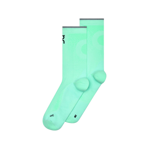 Et par ON Elite Run Sock High Hyper-sokker i farvekombinationen Celeste/Verdite, der har et mintgrønt design i ankelhøjde med grå kant øverst, sort tekst nær manchetten samt »L«- og »R«-mærker på tæerne for at skelne mellem venstre og højre sok. De unisex-sokker vises side om side på en hvid baggrund.