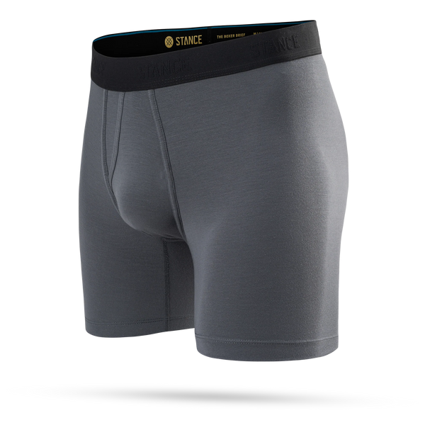 Et par Stance Turbulence Wholester-boxershorts til mænd i gråt, med en sort elastisk linning med Stance-logoet i gul og sort tekst. Disse tætsiddende boxershorts er fremstillet af det bløde Butter Blend-stof og præsenteres her på en ensfarvet hvid baggrund.