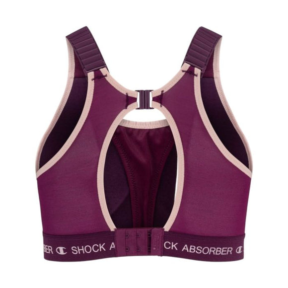 En violet Ultimate Run Bra Padded til kvinder fra Shock Absorber med beige kant, racerback-stropper, et nøglehulsudskæring og justerbare spænder bagpå. Shock Absorber-logoet er synligt på det nederste bånd, hvilket gør denne løbe-bh både stilfuld og yderst støttende til dine træningspas.