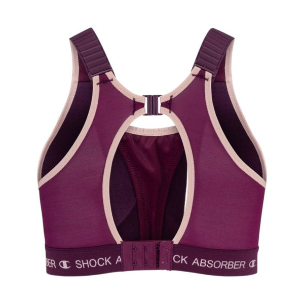 En violet Ultimate Run Bra Padded til kvinder fra Shock Absorber med beige kant, racerback-stropper, et nøglehulsudskæring og justerbare spænder bagpå. Shock Absorber-logoet er synligt på det nederste bånd, hvilket gør denne løbe-bh både stilfuld og yderst støttende til dine træningspas.