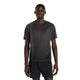 En mand kigger fremad i en New Balance Viz Tech Ss herre T-shirt, sort, med NB ICE-teknologi og sorte shorts - ideel til herretræning - mod en almindelig hvid baggrund.