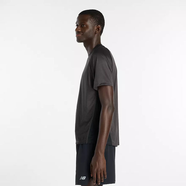 En mand står i profil mod en almindelig hvid baggrund iført New Balance Viz Tech Ss, Herre, Black - en performance-T-shirt med avanceret NB ICE-teknologi for optimal komfort, perfekt til herre-træning.