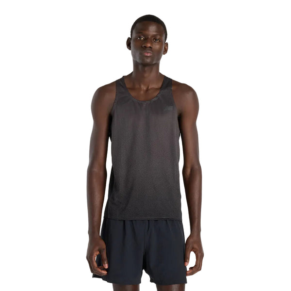 En mand står på en hvid baggrund iført den sorte New Balance Viz Tech Sin løbe singlet herre og sorte shorts, mens han ser lige frem med armene afslappet i siden. Denne singlet tilbyder top atletisk ydeevne og komfort.