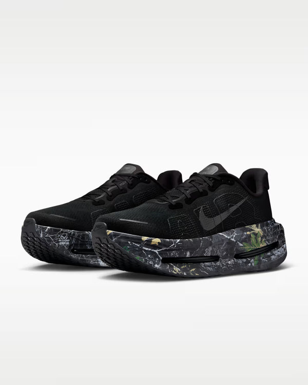 Et par Nike Vomero Premium Herre-sneakers i Black/Mtlc Dark Grey-Dk Smoke Grey "CM", med tykke marmorerede grønne og grå såler og responsiv ZoomX-skum for maksimal komfort, vist på en almindelig lysegrå baggrund.