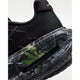 Nærbillede af hælen og sålen på Nike Vomero Premium Herre i Black/Mtlc Dark Grey-Dk Smoke Grey "CM", der viser en synlig Air Max-enhed, grønne blade, en marmoreret mellemsål og Nike-branding på den øverste del af hælen for øget komfort.