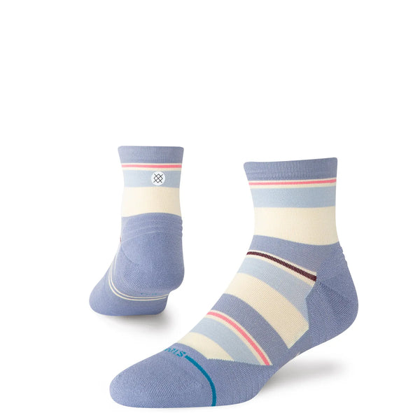 Stance Milo Light Quarter Dame Blue ankellange strømper har en lyseblå hæl, tå og manchet med cremefarvede, blå, brune og røde striber. Disse lette løbesokker vises på højkant, så man kan se dem både forfra og bagfra.