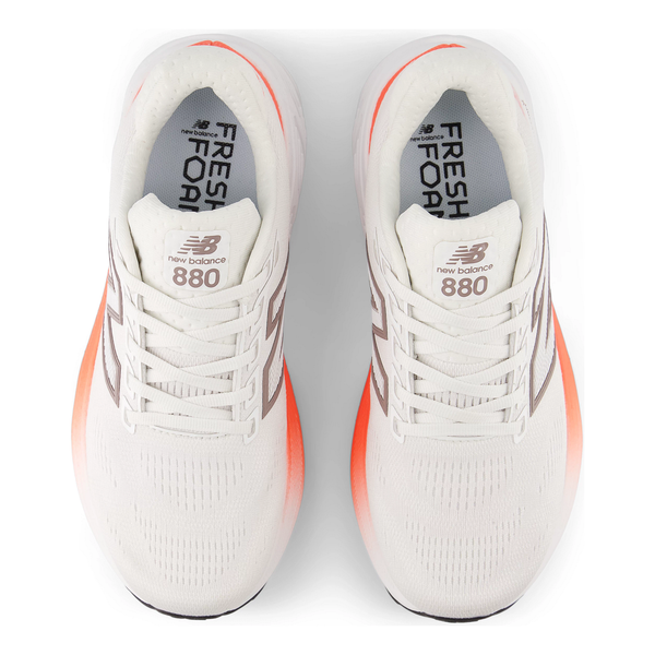 Topbillede af hvid New Balance Freshfoam 880 V15 Dame Reflection løbesko med orange mellemsåler og "Fresh Foam" og "880" branding på indlægssålerne. Grå og sølvfarvede detaljer fuldender disse neutrale løbesko.