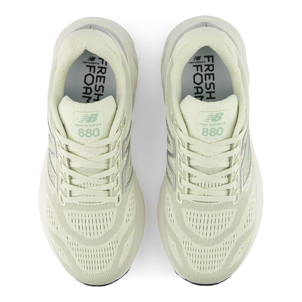 Et blik oppefra og ned viser den lysegrønne New Balance Freshfoam 880 V15 løbesko til dame i mineral, der fremhæver snørebåndene, overdelen i mesh og de brandede indlægssåler, der giver fremragende stødabsorbering på din løbetur.