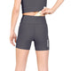 En kvinde ses bagfra, fra taljen til midt på låret, mens hun lægger en genstand i den bageste lomme i linningen på W Combat+ Rib Short Tights 4″ fra Saysky. De grå sportsshorts, der er fremstillet af åndbart ribstof for optimal komfort, har SAYSKY-logoet synligt på venstre ben. Hun har desuden en crop top på.