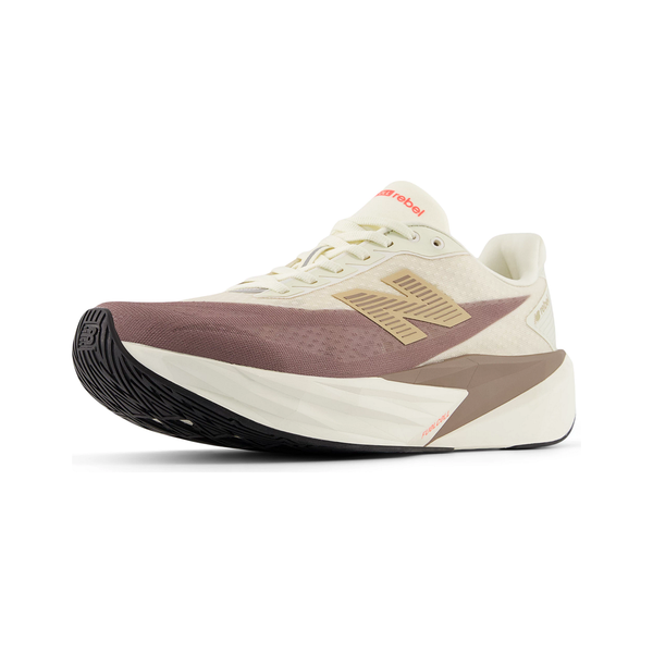 New Balance Fuelcell Rebel V5, Dame, Angora er en beige og lilla letvægt løbesko med en tyk hvid mellemsål, sort gummiydersål, lysebrunt "N"-logo, snørelukning og diskret rød branding på tungen.