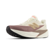 New Balance Fuelcell Rebel V5, Dame, Angora er en beige og lilla letvægt løbesko med en tyk hvid mellemsål, sort gummiydersål, lysebrunt "N"-logo, snørelukning og diskret rød branding på tungen.