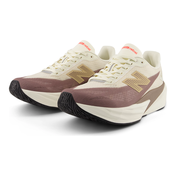 Et par New Balance FuelCell Rebel V5 Dame Angora løbesko i beige med pink detaljer, overdel i mesh, fede logoer på siden, tykke strukturerede såler med sorte ydersåler og en tunge med rødt New Balance-mærke.